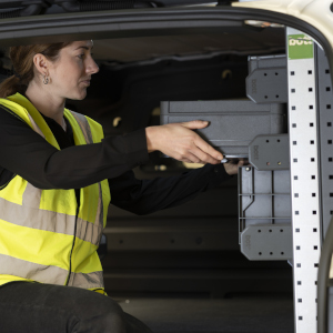 Women in hi-vis slotting a Systainer case into custom van racking solution