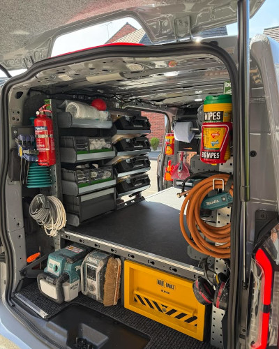 Exterior shot looking into back of van - custom van racking design with shelving, van storage boxes and van false floor